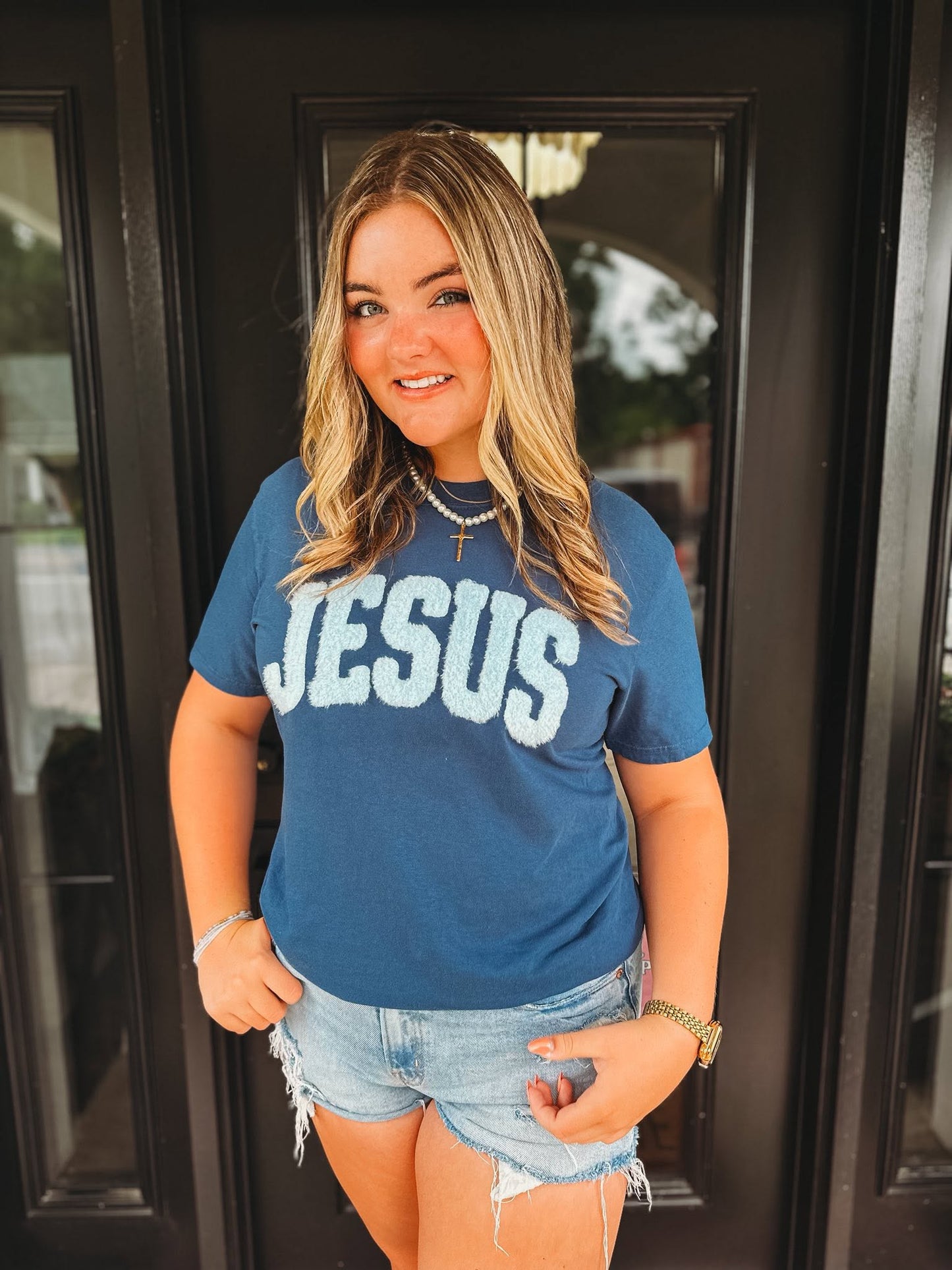 woman wearing midnight comfort colors Jesus christian t-shirt with blue chenille patch